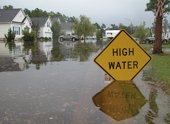 Flooded neighborhood with a sign that reads high water